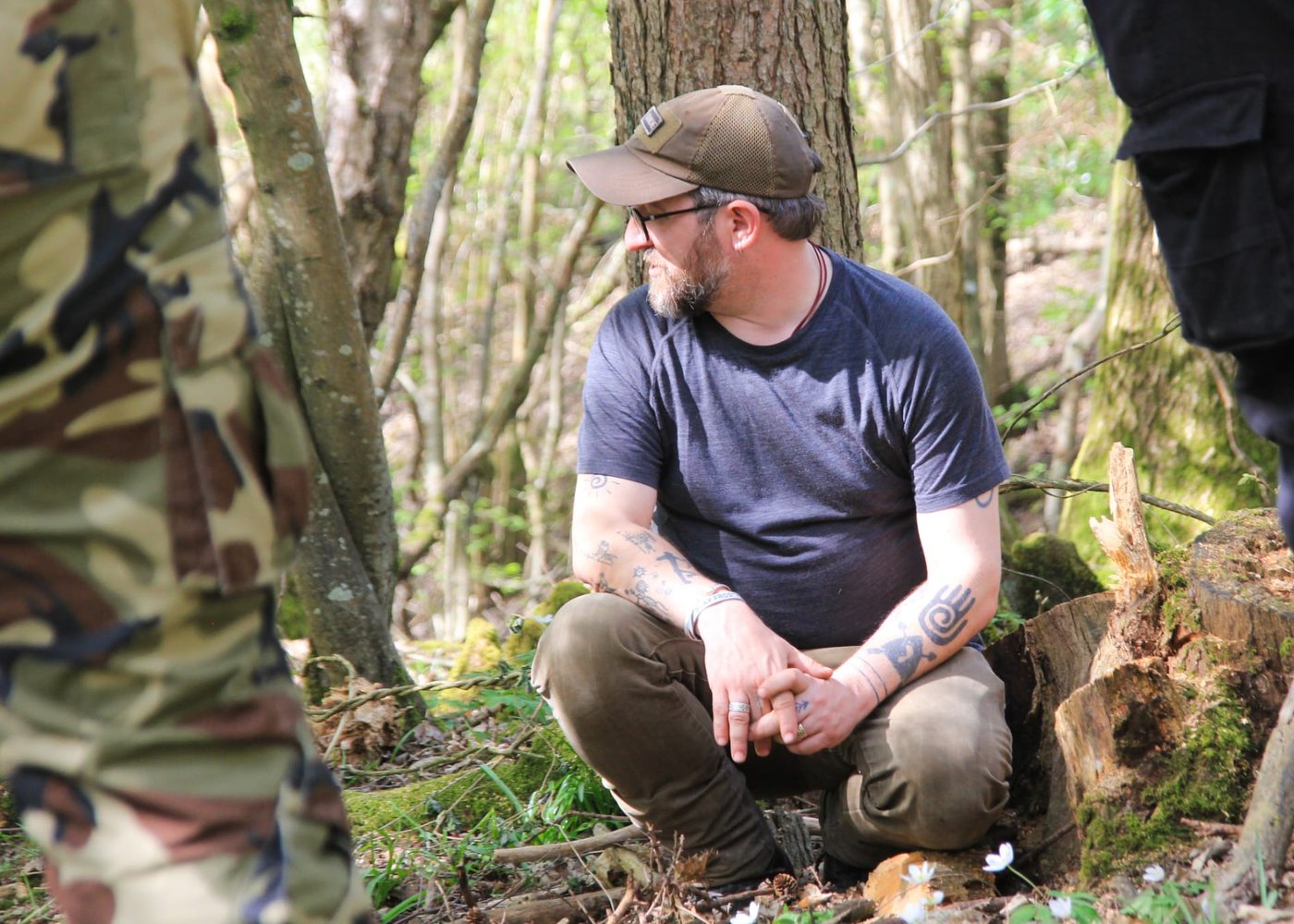 Sam crouched in a sunlit wood, listening, in conversation with the people around him.