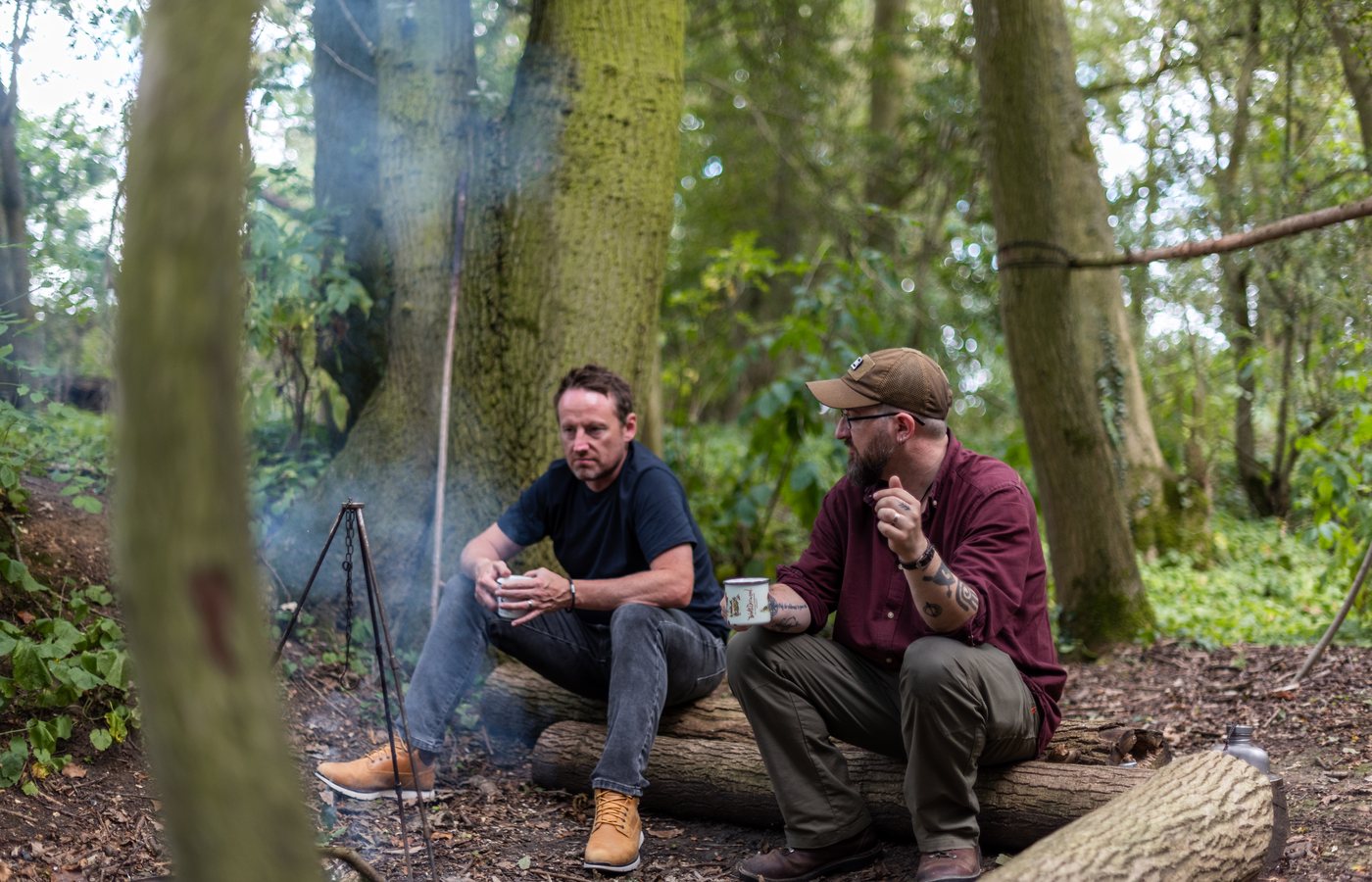 A small group gathered around a fire in the woods at one of Sam's outdoor camps.